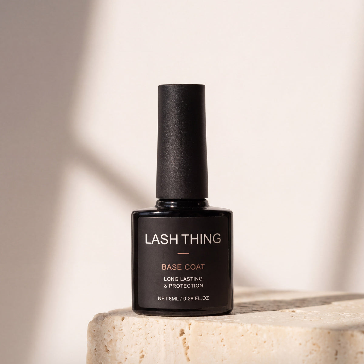 Lashthing Nail Basecoat op travertin in zonlicht